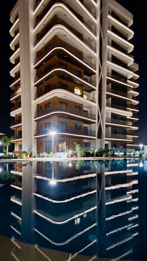 The Infinity residence lit up at night above the pool