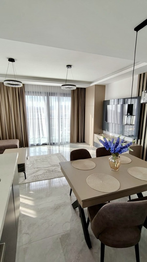 Dining table for four with the lounge and balcony doors beyond