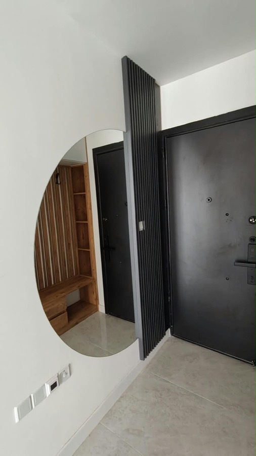 Entrance hall with round mirror and smart-lock door