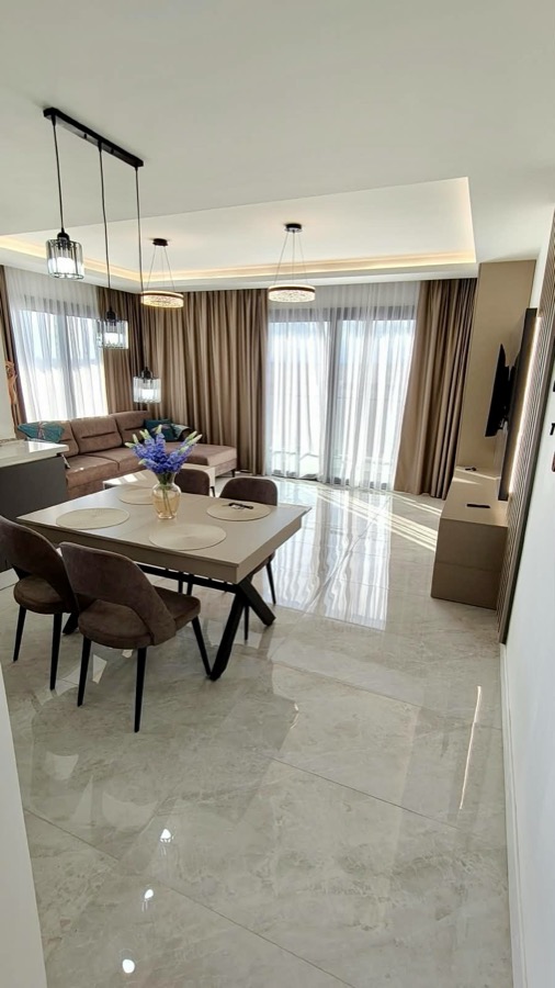 Sunlit open-plan living room with marble floors and dining table