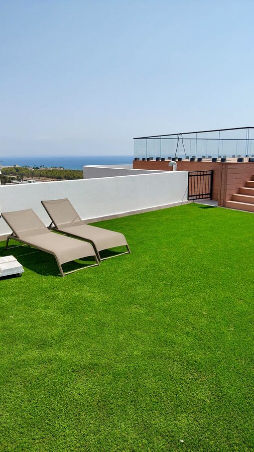Rooftop lawn with sun loungers above the sea